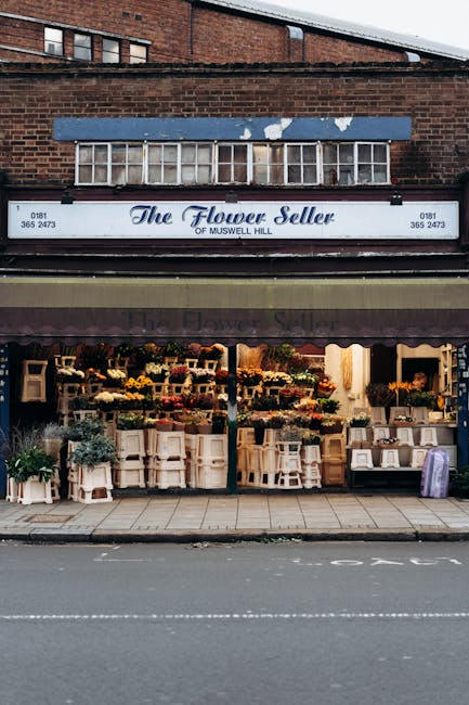 Exterior view of The Flower Seller shop on Muswell Hill, showcasing a vibrant floral display in front of the store. The arrangement includes a variety of fresh flowers such as yellow daffodils, purple